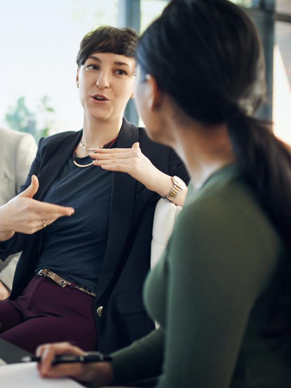Frau im Meeting erklärt Mitarbeitern etwas