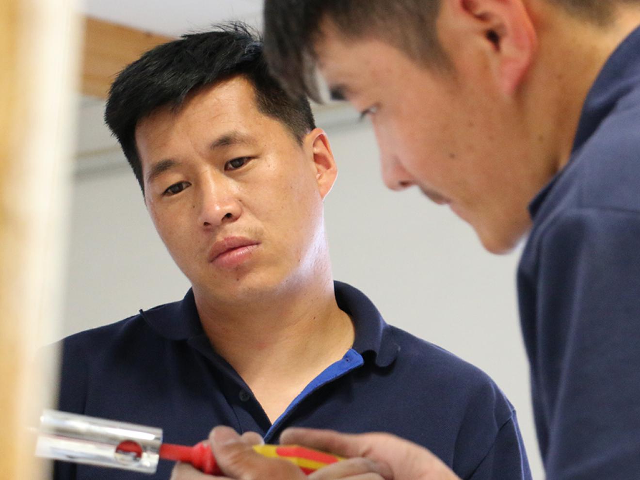 Two people looking at a tool