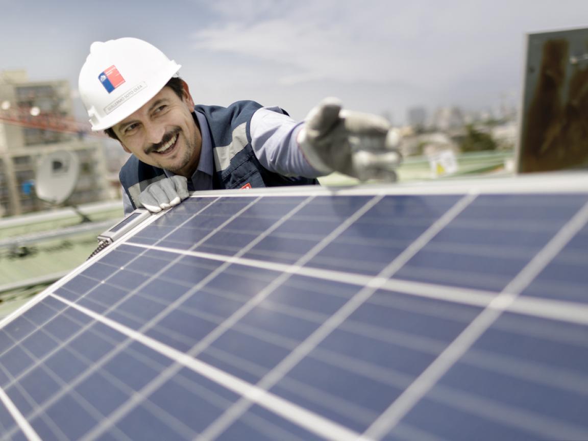 Ein Arbeiter an einer Solaranlage auf dem Dach des Museo de la Memoria, Museum der Erinnerung und Menschenrechte. Santiago de Chile.
