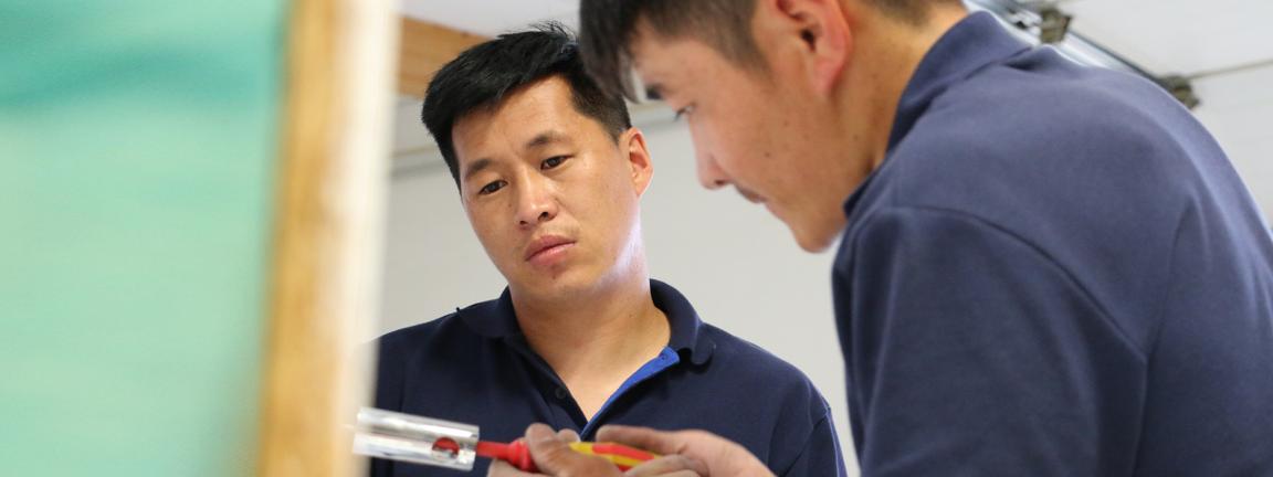 Two people looking at a tool